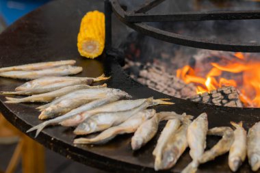 Avrupa yemekleri pişirme süreci, gıda festivalinde siyah brazier üzerinde balık eridi.