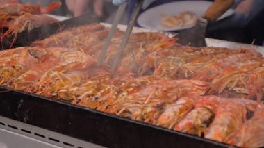 Yavaş çekim: şef yaz yerel yemeklerinde ızgarada taze kırmızı langoustine pişiriyor.