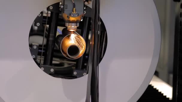 Машина лазерной резки, работающая с цилиндрической металлической заготовкой с искрами — стоковое видео