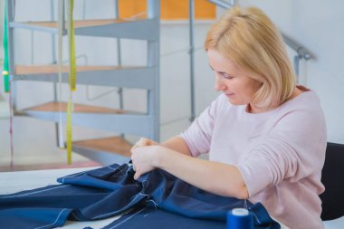 Profesyonel terzi, moda tasarımcısı dikiş stüdyosunda çalışıyor.