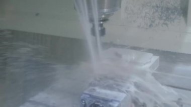 Fabrikada metal işçiliği kesen soğutma sistemi olan bir değirmen makinesi.