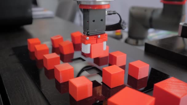 Pick and place robotic arm manipulator moving red toy blocks at robot exhibition — Stock Video