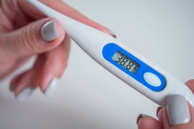 Yakın çekim: yüksek sıcaklıkta dijital medikal termometre tutan kadın