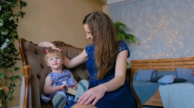 Evdeki komik küçük kız ve annesinin portresi.