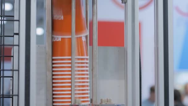 Производство оранжевых кофейных чашек на полностью автоматической машине для изготовления бумажных чашек — стоковое видео