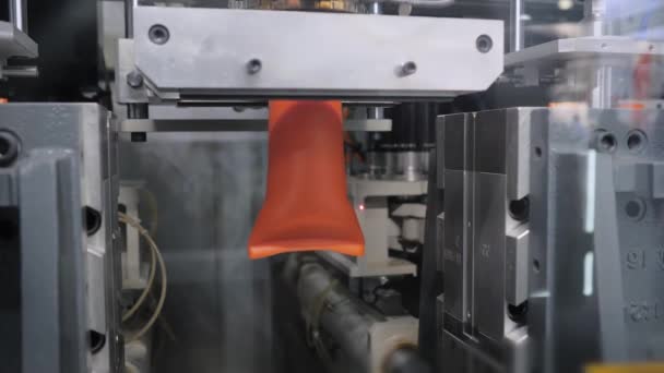 Automatisk støpemaskin: Produksjon av tomme oransje plastjerrykaner – stockvideo
