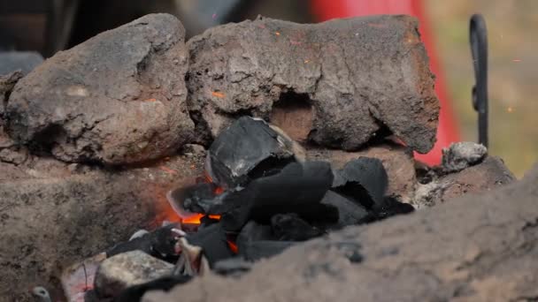Kovář topení kovový kus ve venkovní kovárně na medival festivalu - zblízka — Stock video