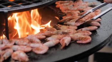 Yavaş çekim: Aşçı taze kırmızı kral karidesleri ızgarada kızartıyordu.