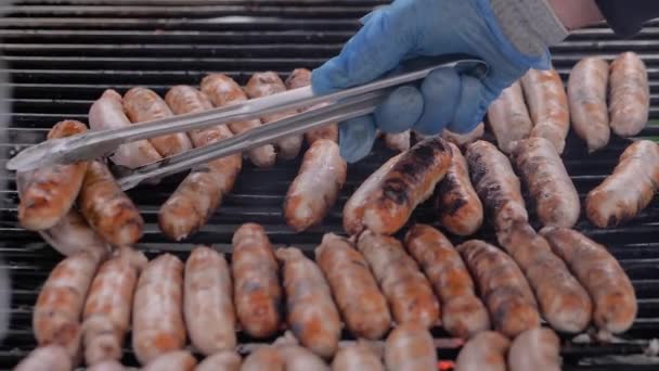 Slow motion: kock grilla färskt kött korv på stora runda hängande grill — Stockvideo
