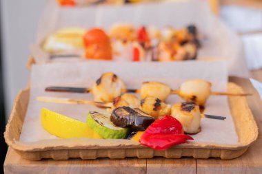 Yakın çekim: pişmiş taze deniz tarağı et şişleri kağıt kutuları: sokak yemekleri