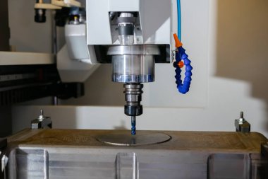 Fabrikada metal işçiliği kesen soğutma sistemi olan bir değirmen makinesi.