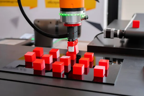Escolha e coloque o manipulador de braço robótico movendo blocos de brinquedo vermelho na exposição do robô — Fotografia de Stock