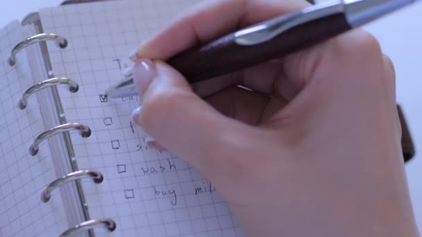 Vista de cerca - mujer poniendo marca en las casillas de verificación de hacer lista en el cuaderno — Vídeos de Stock