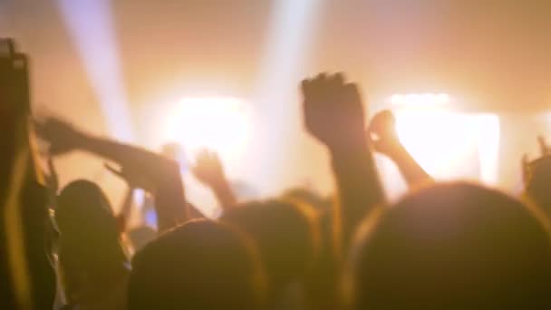 Yavaş çekim: Sahnenin önündeki rock konserinde parti yapan insanların siluetleri — Stok video
