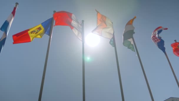 Kleurrijke vlaggen wapperen in de wind - super slow motion - diplomatie concept — Stockvideo