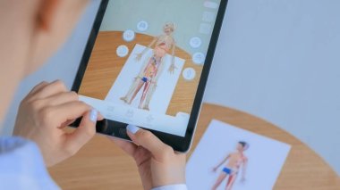 Artırılmış gerçeklik uygulaması olan tablet kullanan kadın: İnsan vücudunun 3 boyutlu modeli