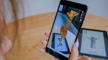 Artırılmış gerçeklik uygulaması olan tablet kullanan kadın - hayvanların sanal 3D modelleri