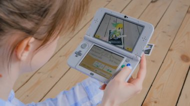 Oyun konsolu kullanan kadın oyuncu AR uygulaması ile Nintendo 3ds