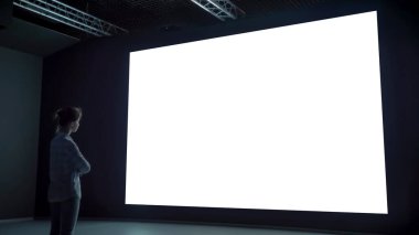 Boş büyük etkileşimli duvar görüntüsüne bakan kadın - beyaz ekran konsepti