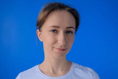 Olumlu kadın gülümsüyor ve odadaki kameraya bakıyor. Kapat.