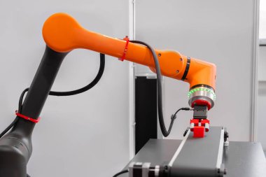 Robot kol manipülatörü robot sergisinde kırmızı oyuncak bloklarını hareket ettiriyor ve yerleştiriyor