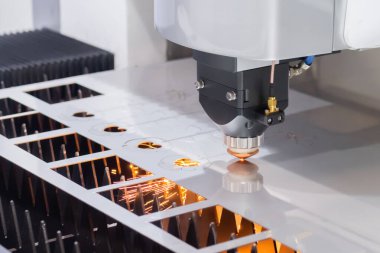 Lazer kesme makinesi fabrikada kıvılcımlarla metal levha ile çalışıyor.