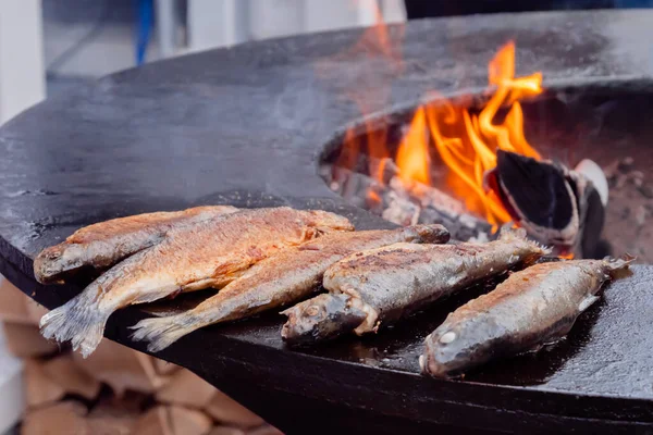 フードフェスティバルの火鉢でヨーロッパの魚を調理するプロセス:クローズアップ — ストック写真