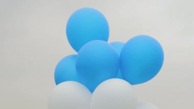 Açık hava festivalinde rüzgarda savrulan renkli balonlar gri gökyüzüne karşı: