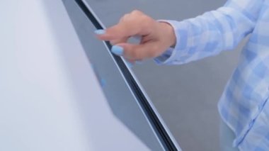 Modern müzede ya da sergide etkileşimli dokunmatik ekran kullanan kadın