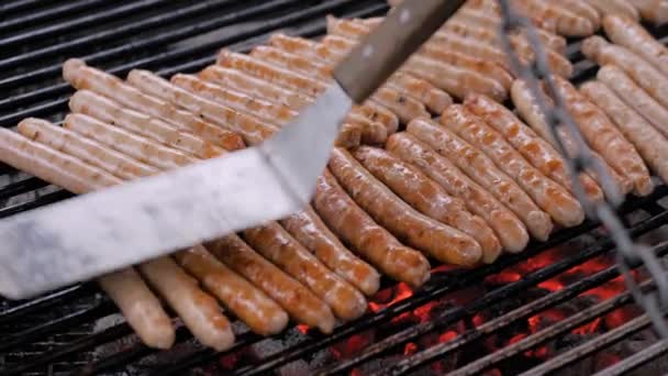 Chef grilling fresh meat sausages on big round hanging grill - slow motion — Stock Video