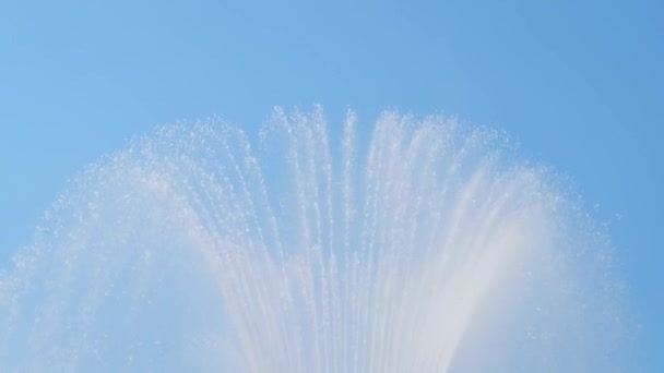Fountain water jet splashing against blue sky - slow motion — Stock Video
