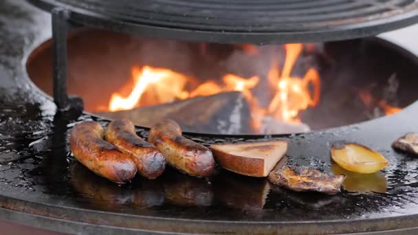 Slow motion: chef-kok grillen worsten, plak toast brood, peper op ronde grill — Stockvideo