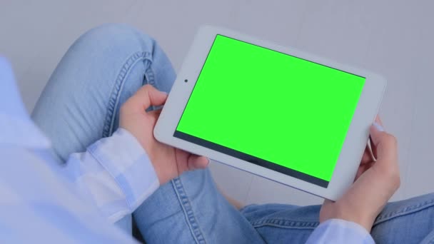 Vrouw op zoek naar tablet computer met leeg groen scherm - copyspace concept — Stockvideo