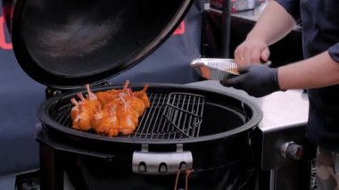 Şef sokak yemekleri festivalinde tavuk budu ve baharat hazırlıyor.