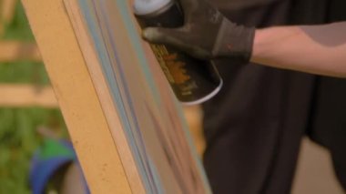 Adam graffiti festivalinde konserve kutusundan boya püskürtüyor. Yavaş çekim.