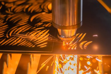 Lazer kesme makinesi, kıvılcımlı metal levha ile çalışıyor. Kapat.