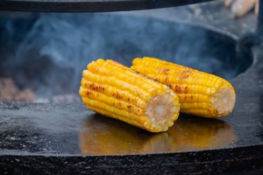 Sağlıklı sarı mısırı mangalda pişirme işlemi sokak yemekleri pazarında.
