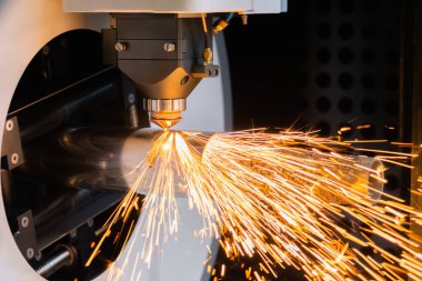 Lazer kesme makinesi, silindirik metal kıvılcımlarla çalışıyor.