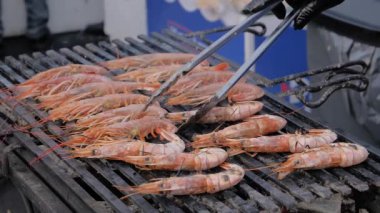 Yavaş çekim: Şef Brezilya usulü taze karides ızgara yapıyor.