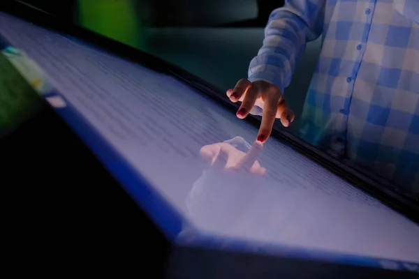 Woman hand using touchscreen display of interactive kiosk at exhibition: closeup