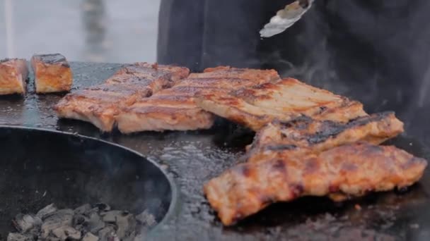 Медленное движение: шеф-повар с щипцами жарит мясные стейки на жаровне с горячим пламенем — стоковое видео