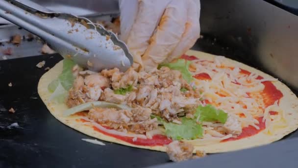 Медленное движение: шеф-повар с щипцами делает мексиканское тако с мясом: крупным планом — стоковое видео