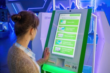 Modern müzede ya da sergide interaktif dokunmatik yeşil kiosk kullanan kadın