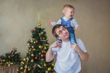 Gülümseyen oğlunu omuzlarında taşıyan mutlu bir baba.