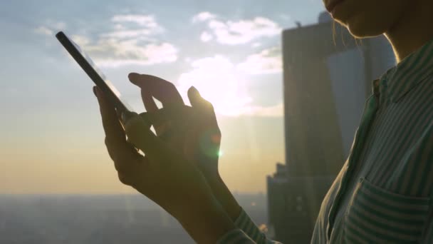 Γυναικείο χέρι χρησιμοποιώντας smartphone κατά της ηλιοφάνειας, φωτοβολίδα φακού: close up side view — Αρχείο Βίντεο
