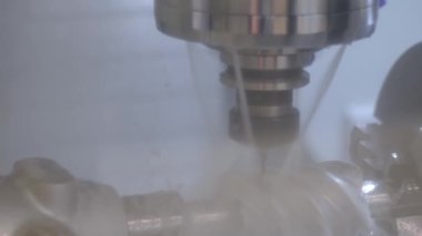 Fabrikada metal işçiliği kesen soğutma sistemi olan bir değirmen makinesi.