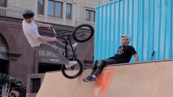 Підліток, який показує стрибки над людьми на велосипеді на скейтпарку. — стокове відео