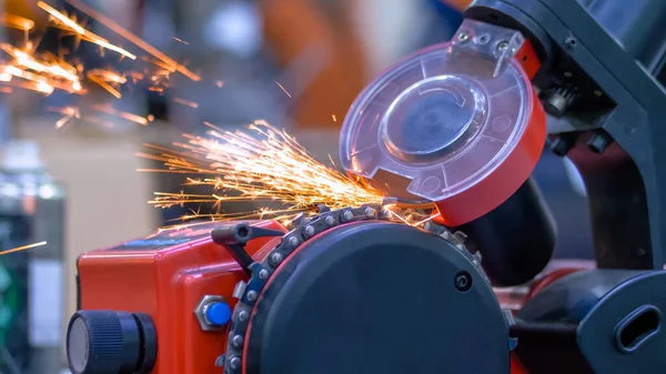 Automatic saw chain sharpening machine during work at workshop - close up