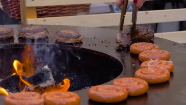 Mouvement lent : le chef grille des steaks, escalopes, saucisses sur brasero à la flamme chaude — Video