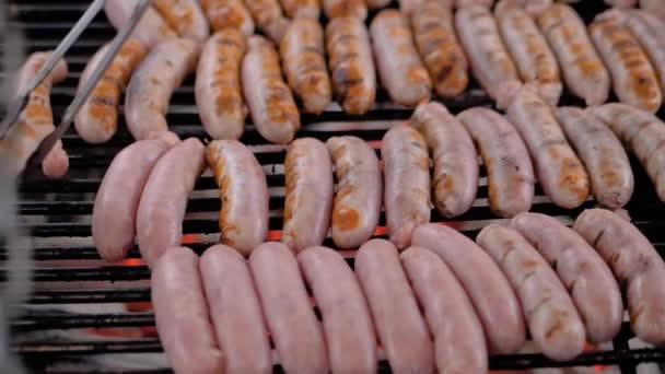 Chef asando embutidos de carne fresca en una gran parrilla redonda - cámara lenta — Vídeo de stock